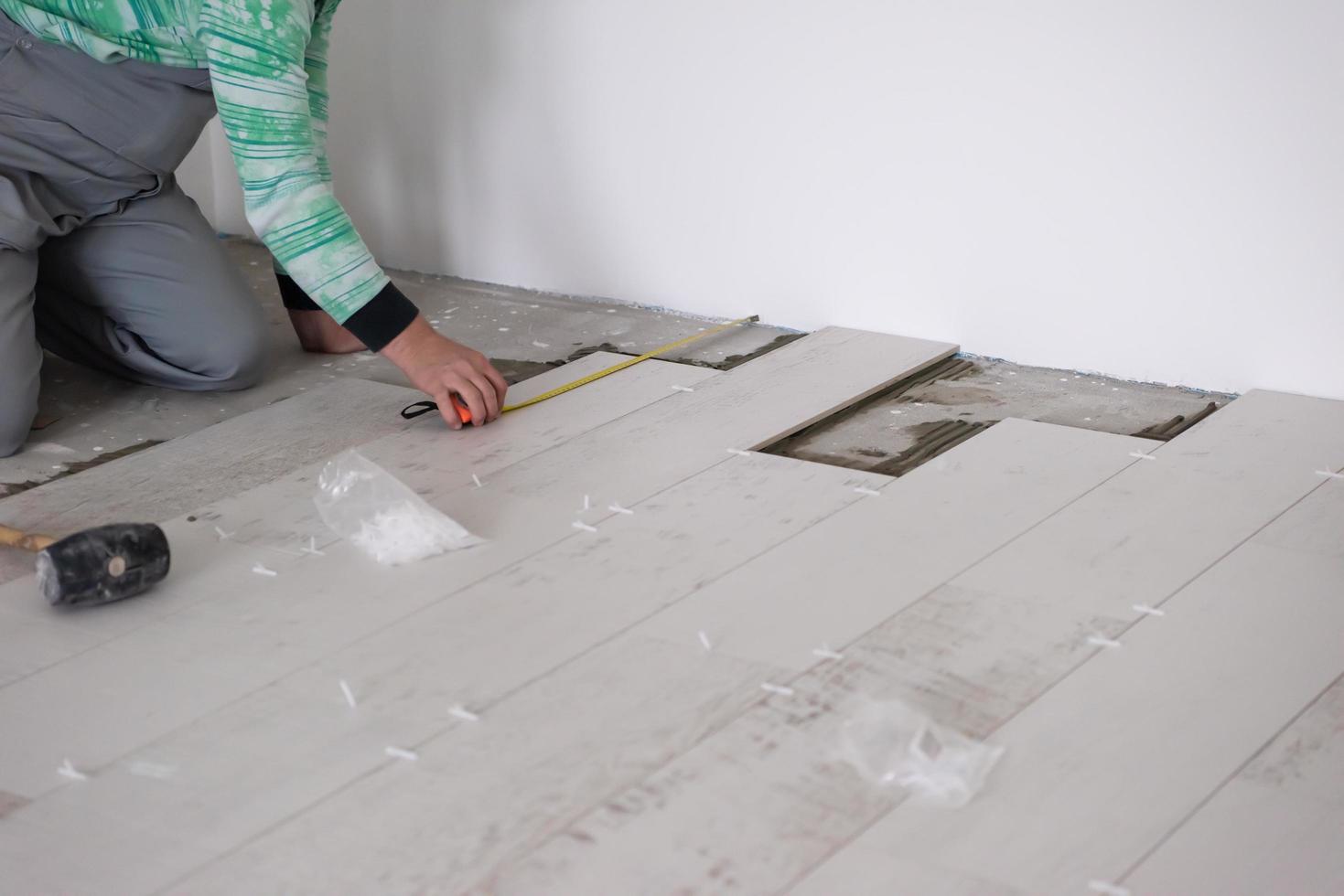 worker installing the ceramic wood effect tiles on the floor photo