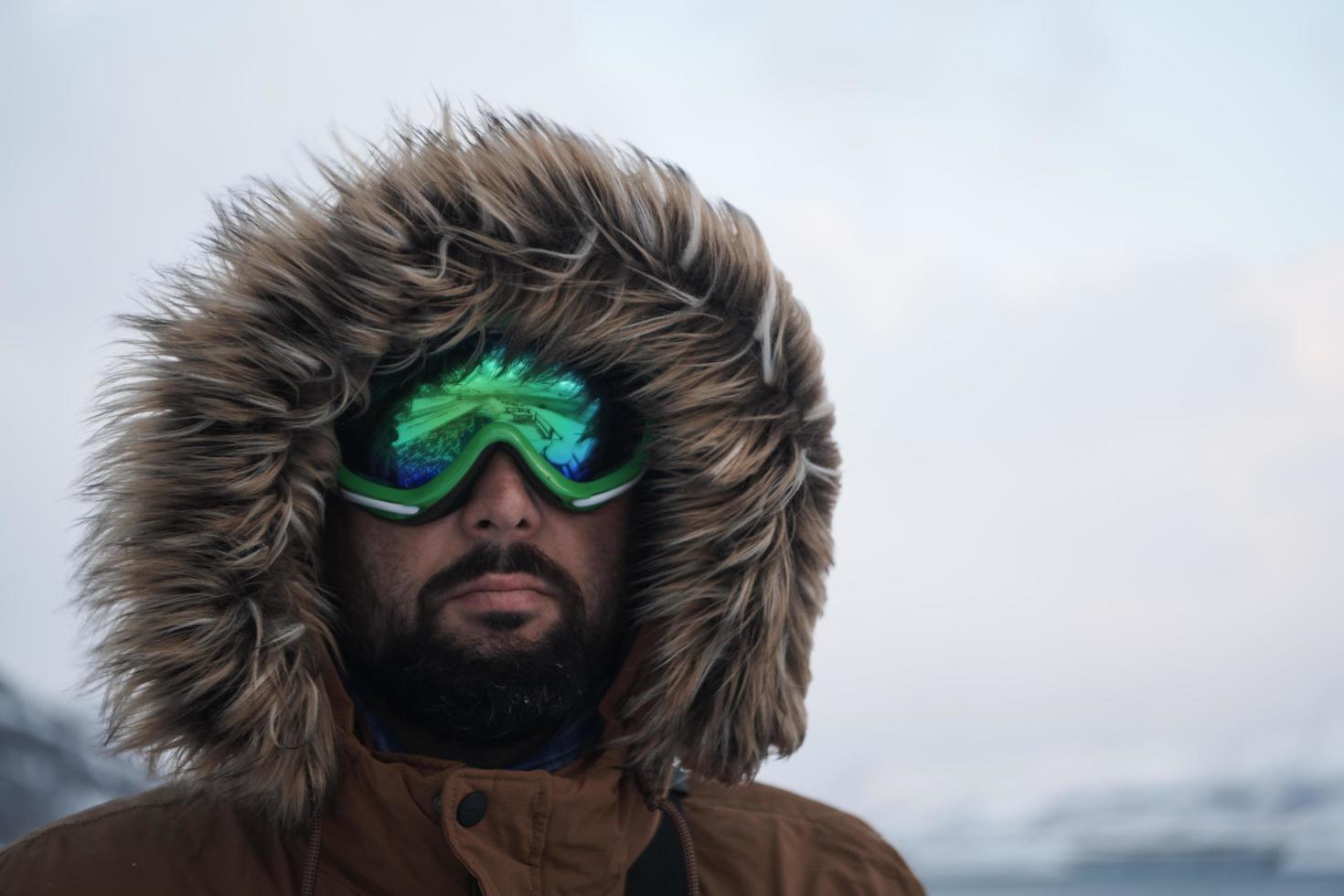 man at winter in stormy weather wearing warm  fur jacket photo