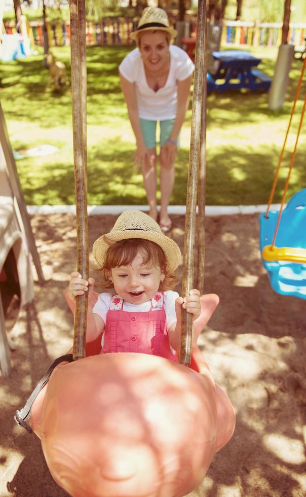 madre e hija columpiándose en el parque foto