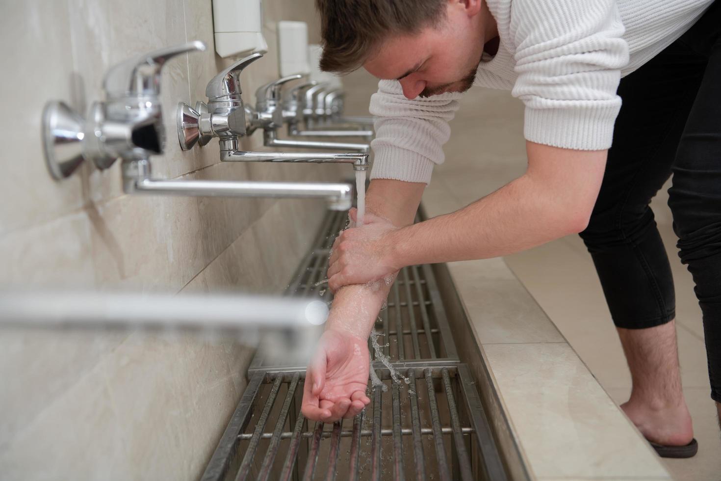 A Muslim takes ablution for prayer. Islamic religious rite photo