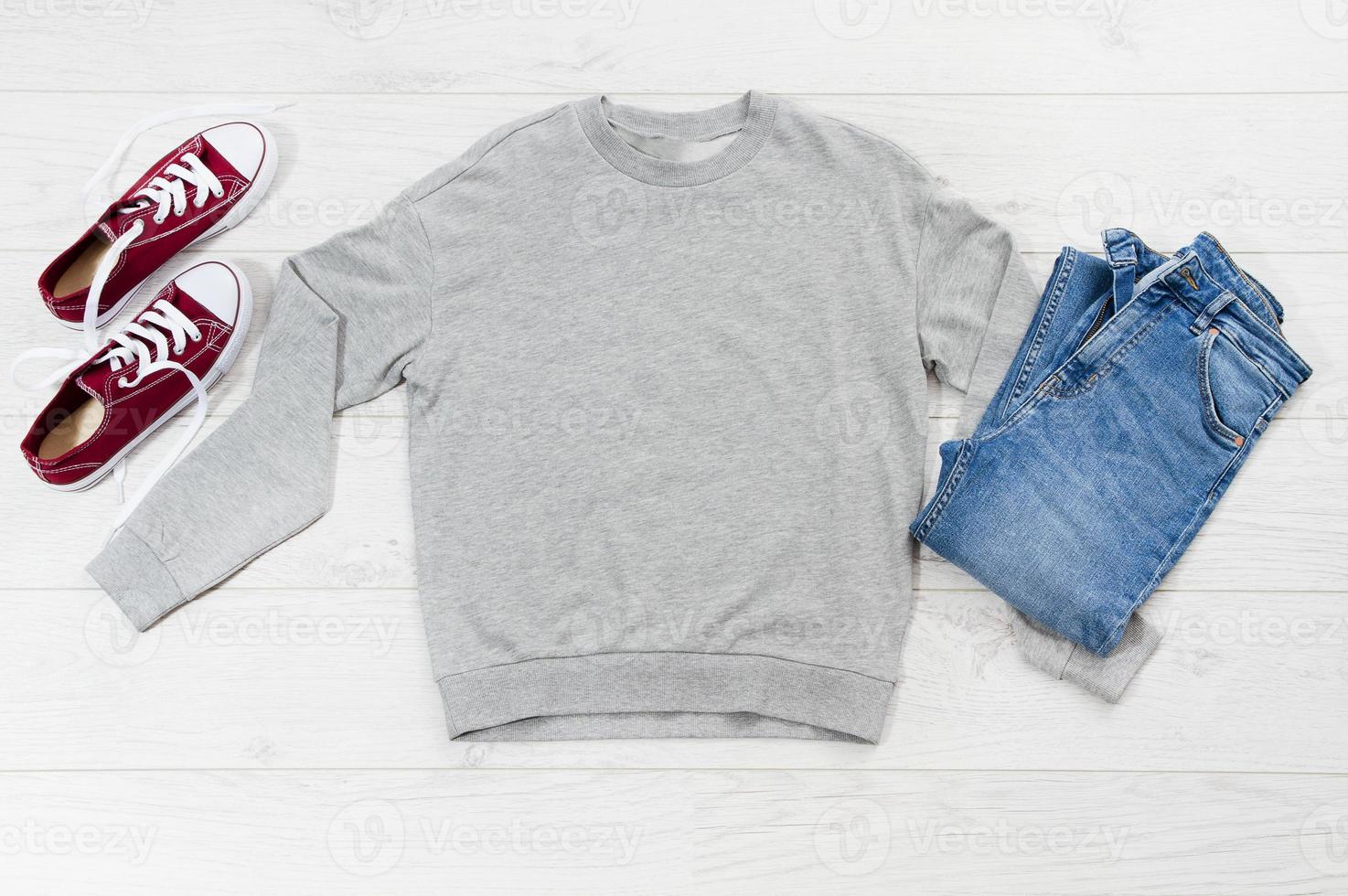 Close up gray blank template sweatshirt hoodie with copy space. Top view mockup pullover on white wooden background. Casual outfit. Flat lay template clothes. photo