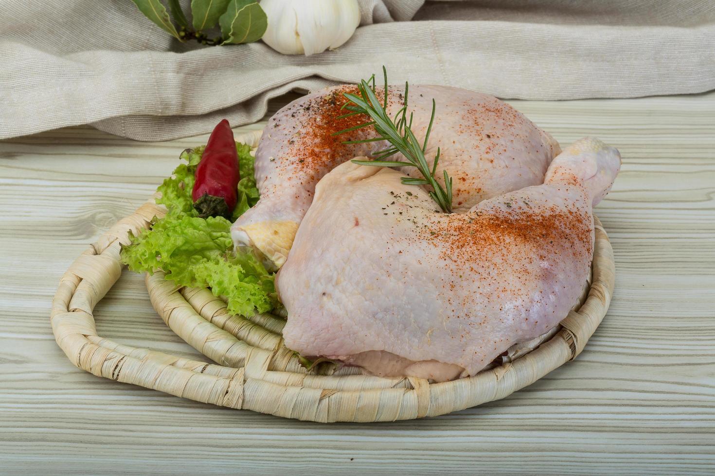 muslo de pollo sobre tablero de madera y fondo de madera foto