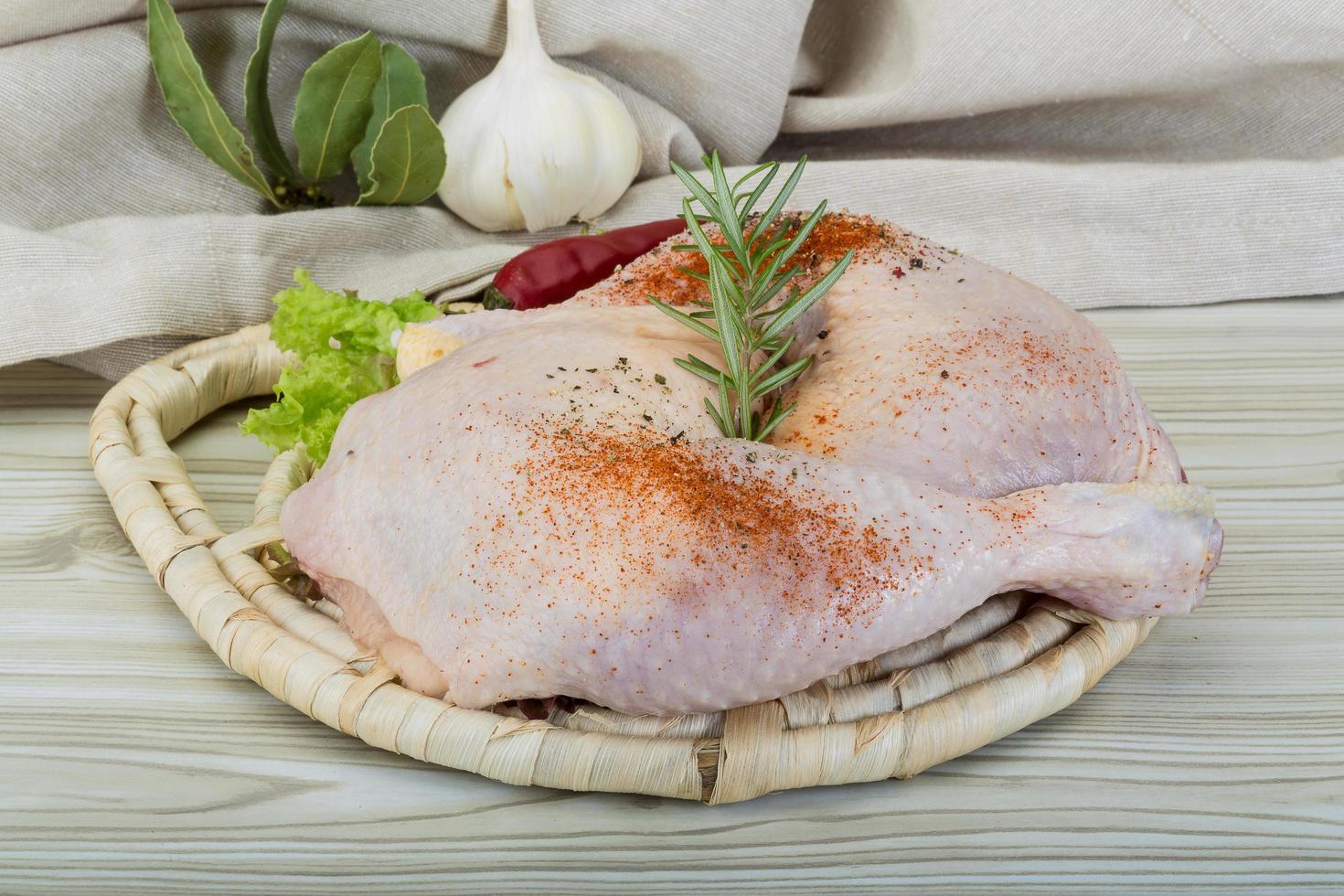 Chicken thigh on wooden board and wooden background photo