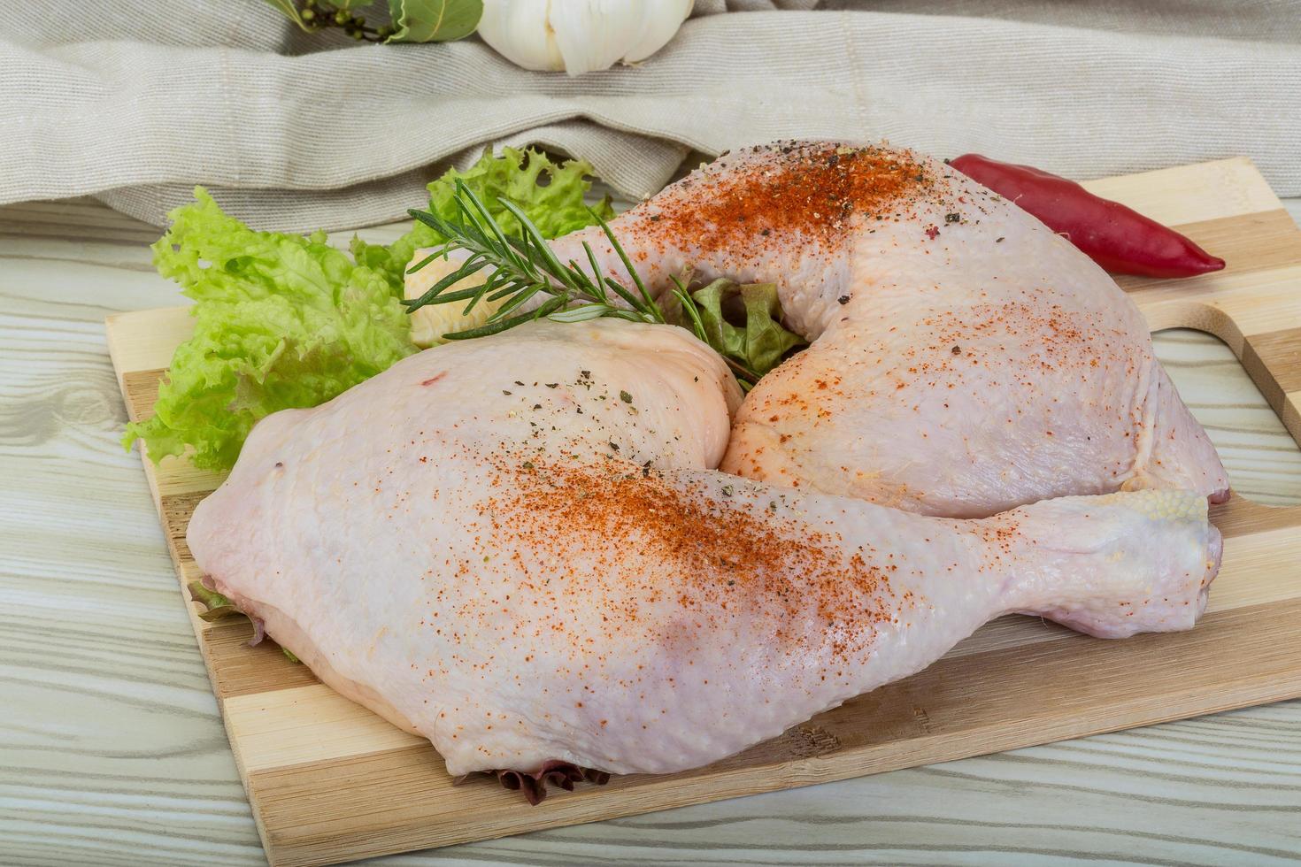 Chicken thigh on wooden board and wooden background photo