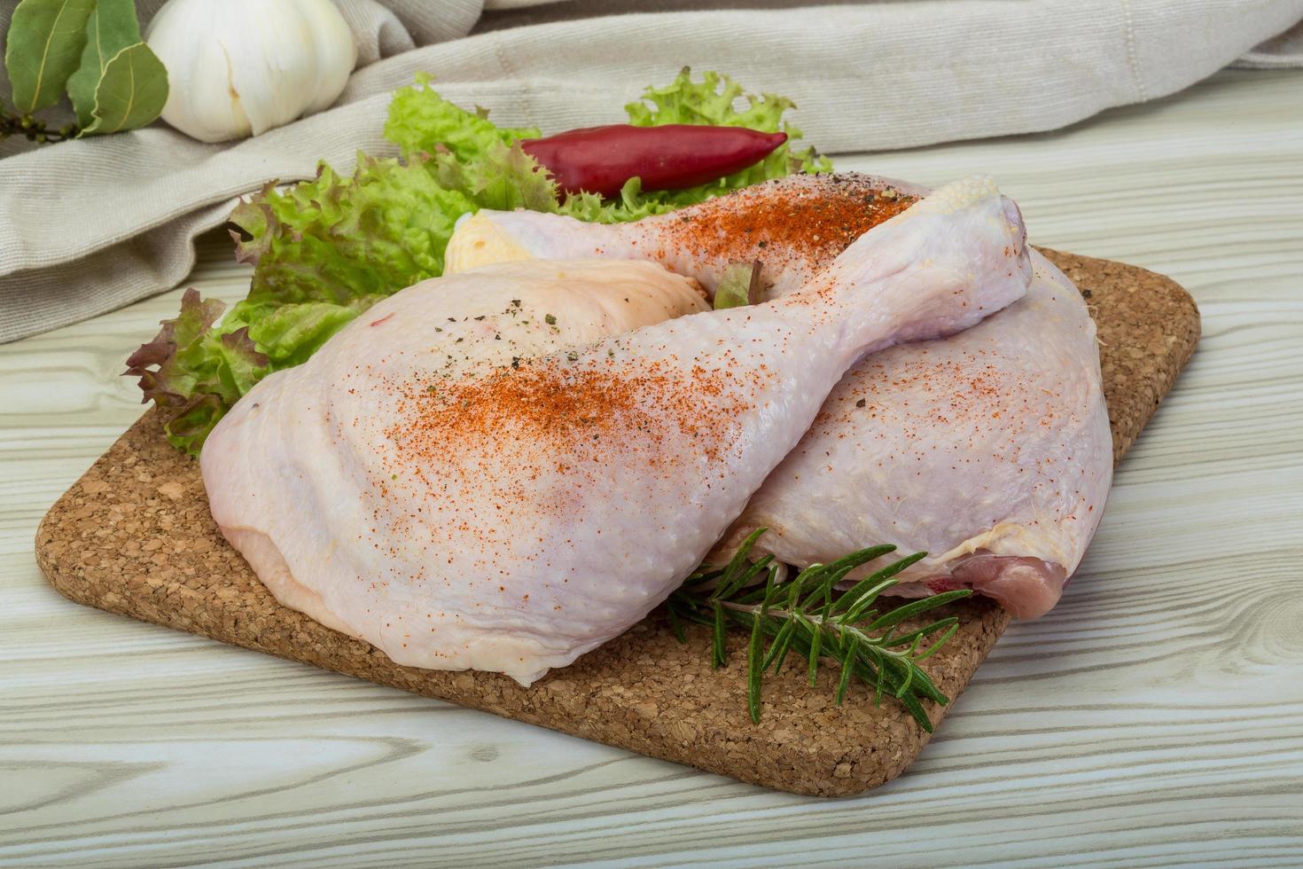 Chicken thigh on wooden board and wooden background photo
