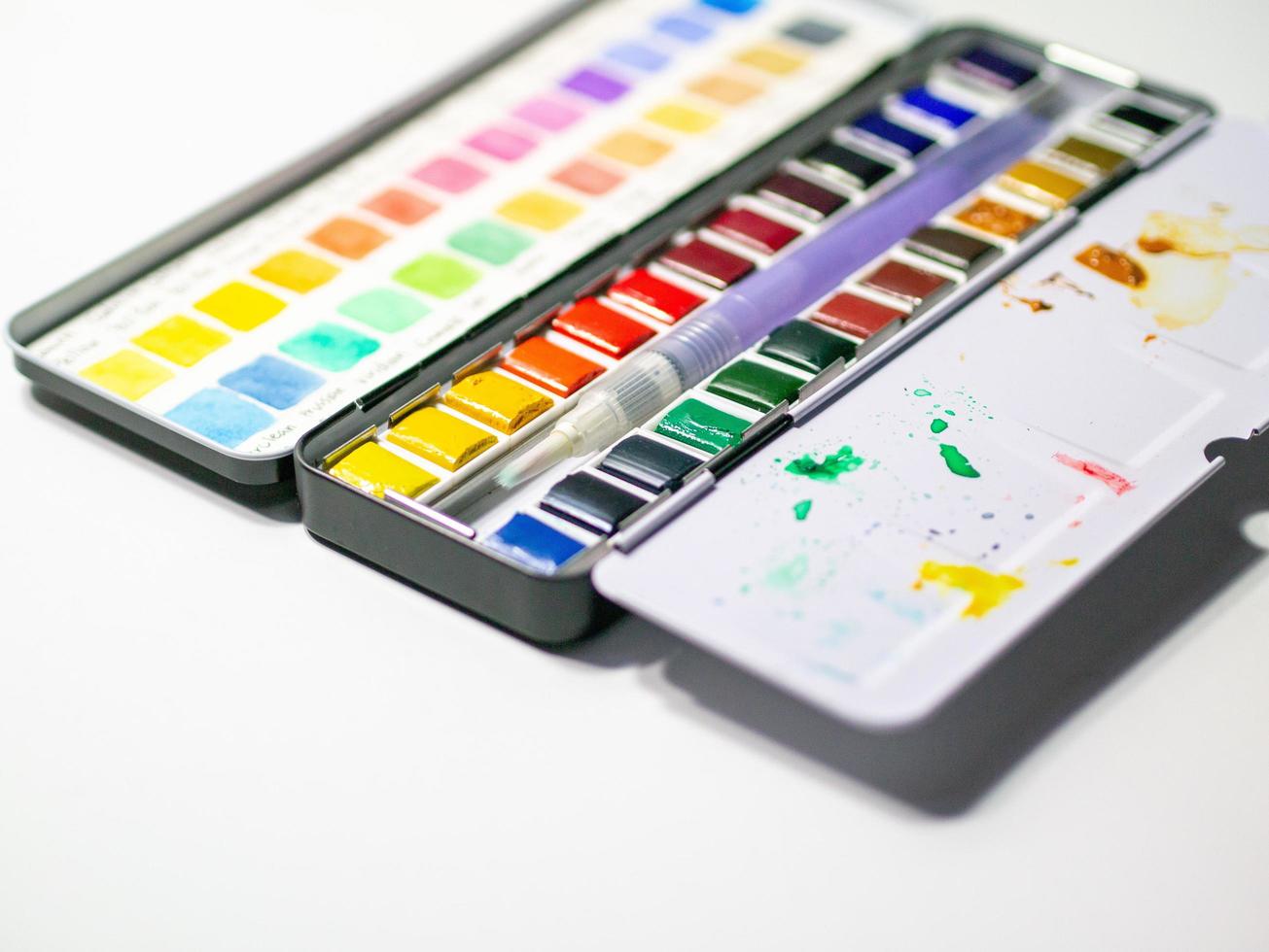 Watercolor pan on white background with color swatch test. photo