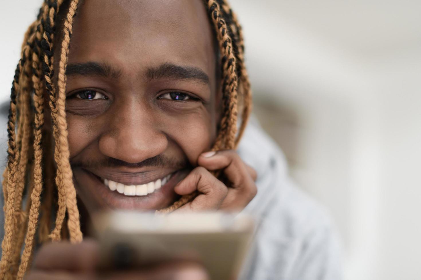 afro guy uses a cell phone and browses social media during a pandemic photo