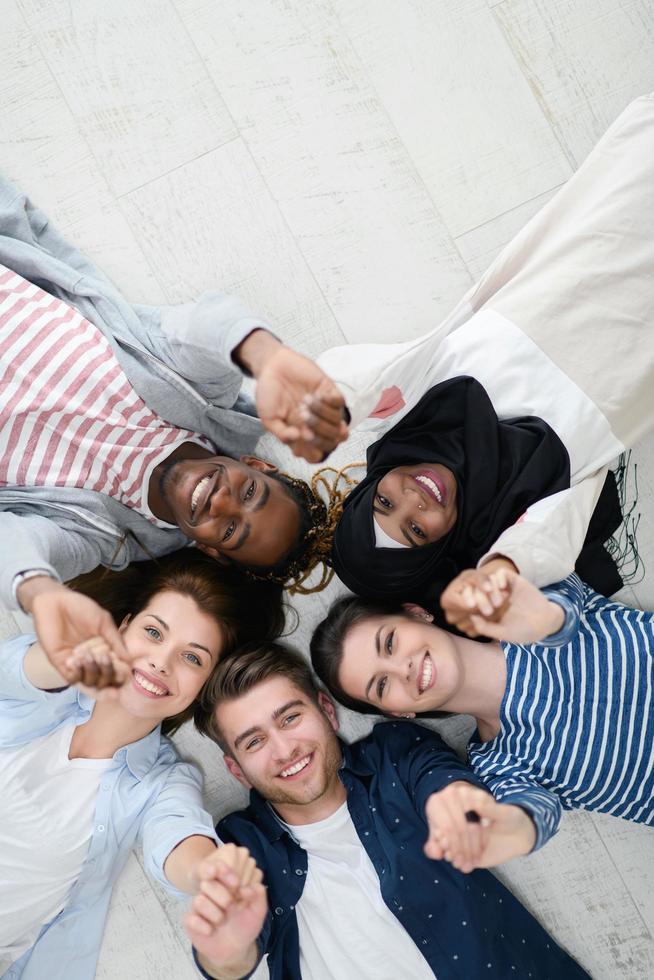 vista superior de un grupo diverso de personas tiradas en el suelo y simbolizando la unión foto