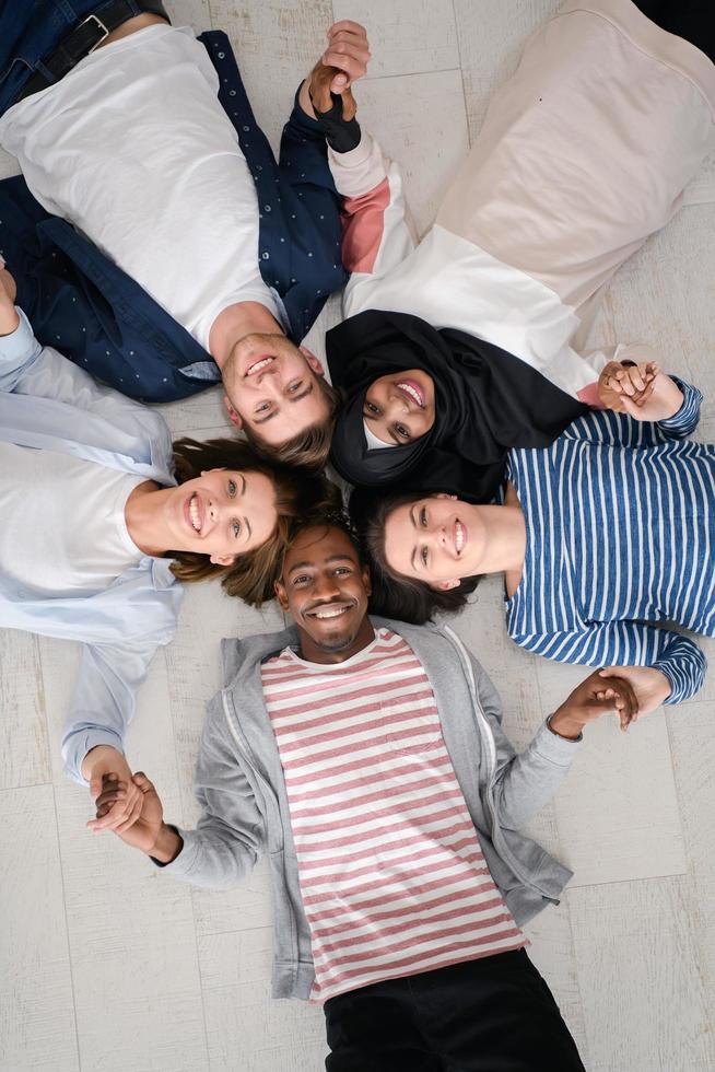 top view of a diverse group of people lying on the floor and symbolizing togetherness photo
