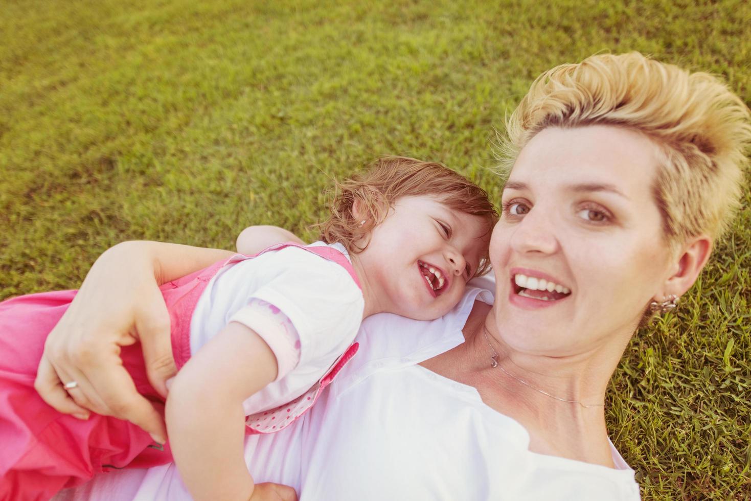 mother and little daughter playing at backyard photo