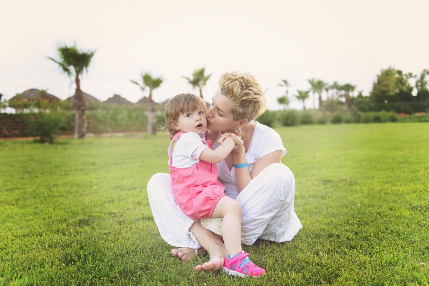 mother and little daughter playing at backyard photo