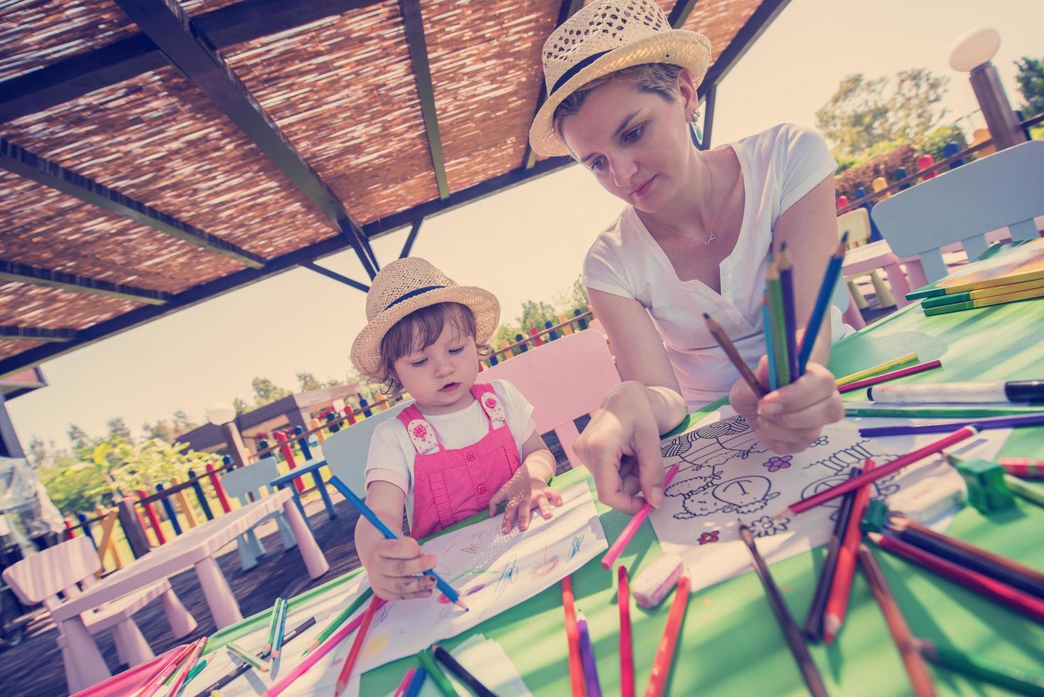 mom and little daughter drawing a colorful pictures photo