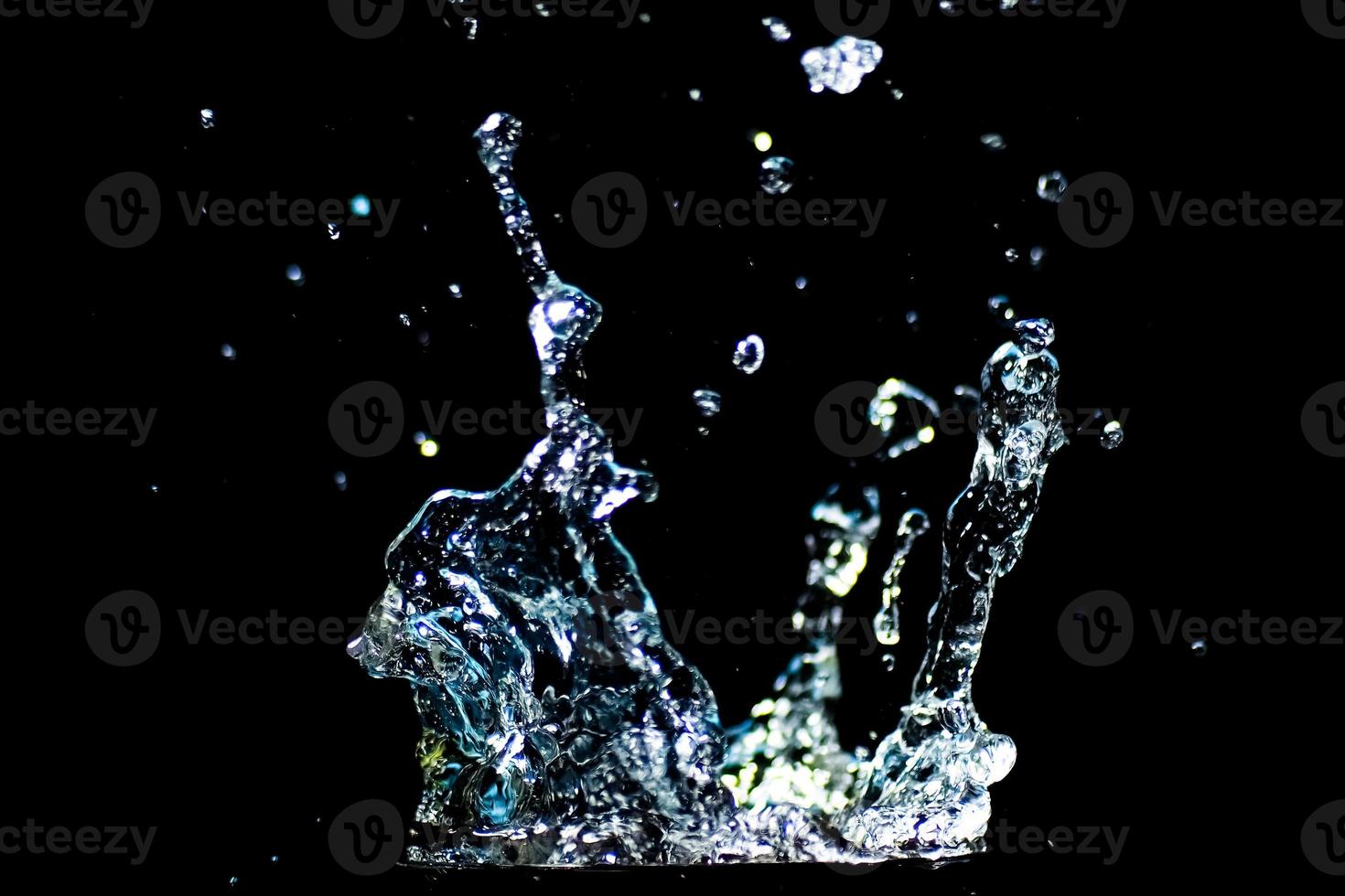 Splashing water on a black background. water droplets scattered on a black background photo