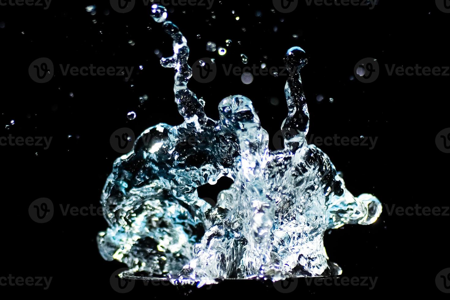 Splashing water on a black background. water droplets scattered on a black background photo