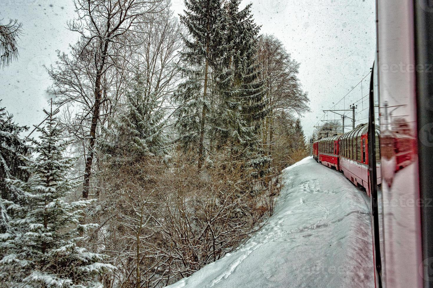 Red train in the snow in swiss alps photo