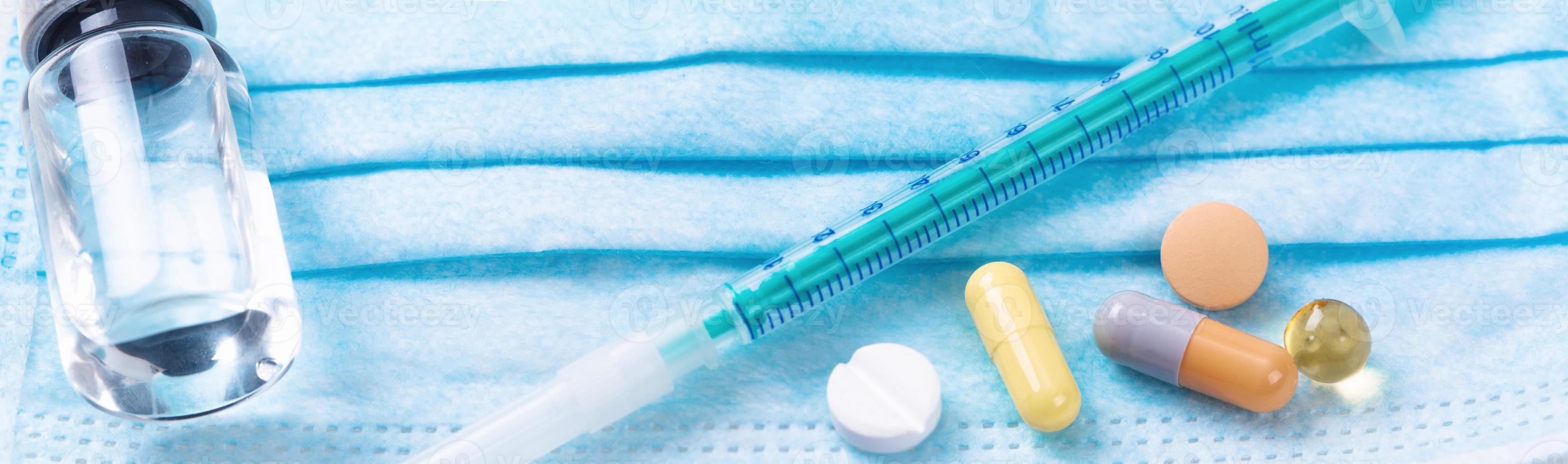 Medical syringe with a needle and pills. Corona virus vaccine. photo