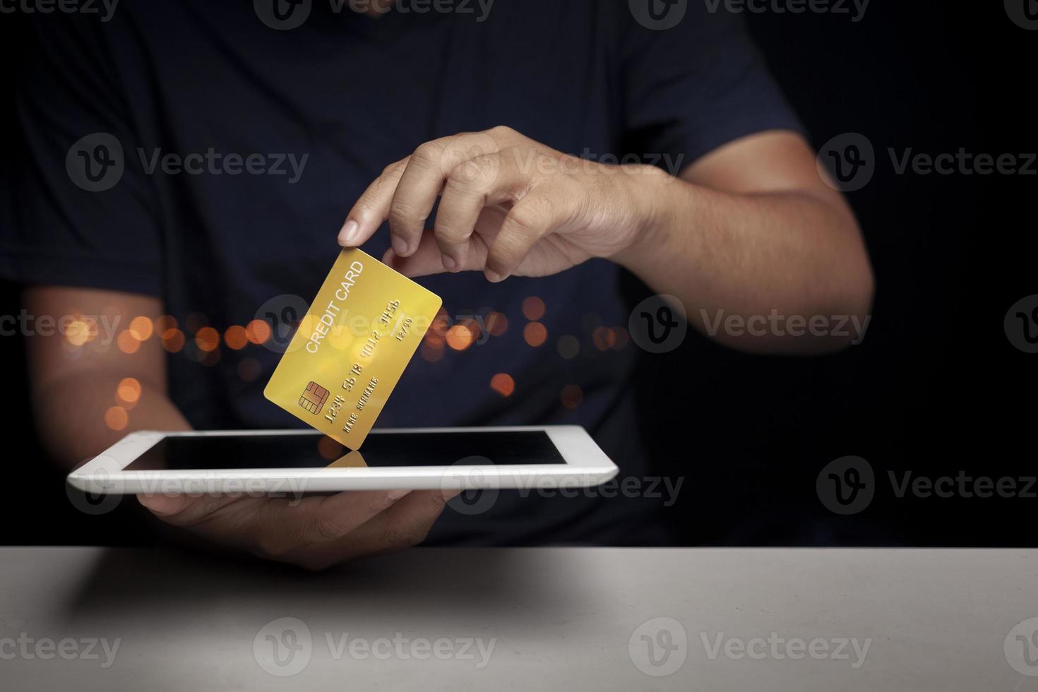 Man holding tablet and showing credit card, focusing on credit card Quick money option ideas photo