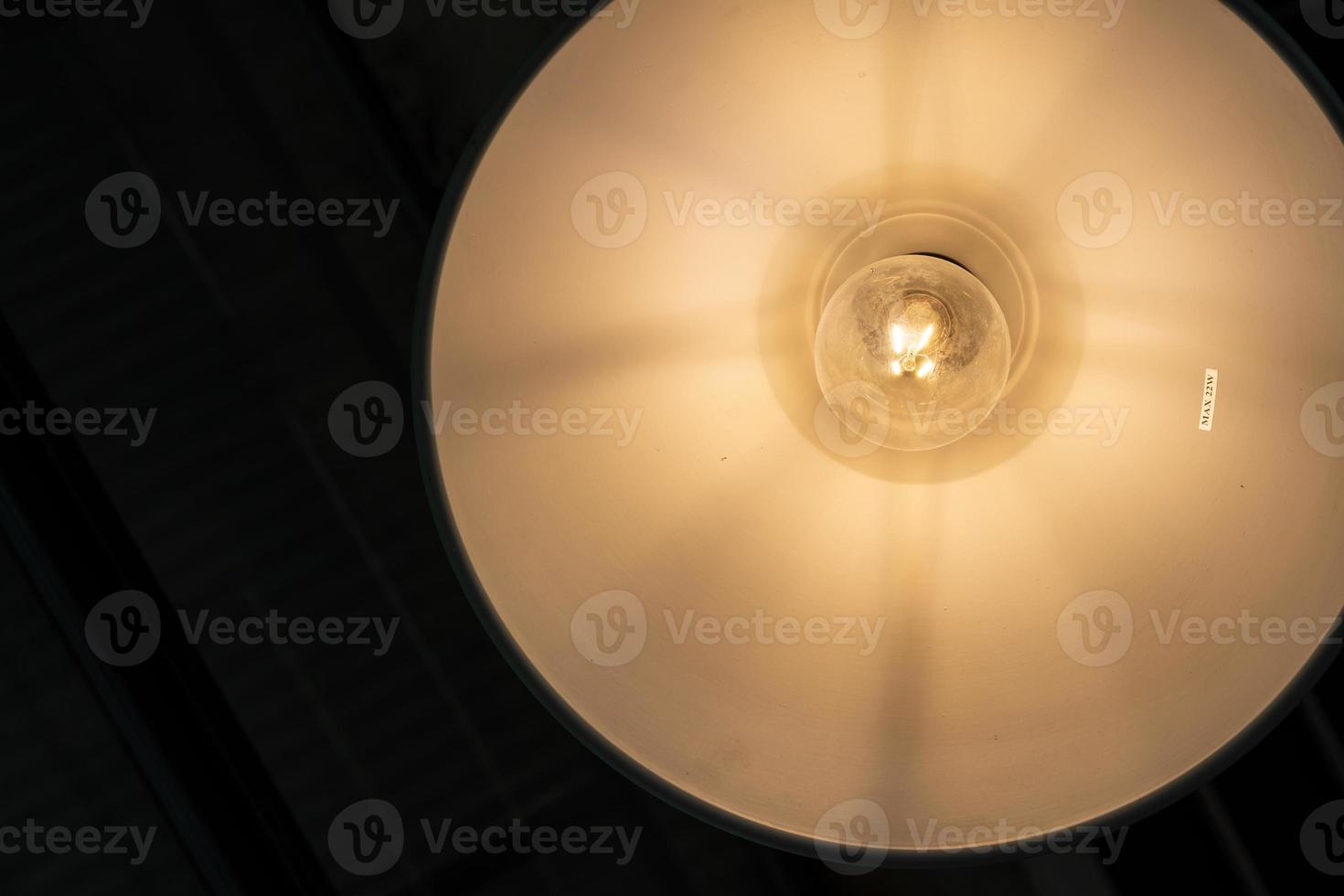 warm lights hanging from ceiling in local restaurant. Close-up shot with blurred background. Negative copy space photo