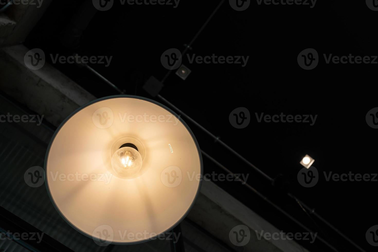 warm lights hanging from ceiling in local restaurant. Close-up shot with blurred background. Negative copy space photo