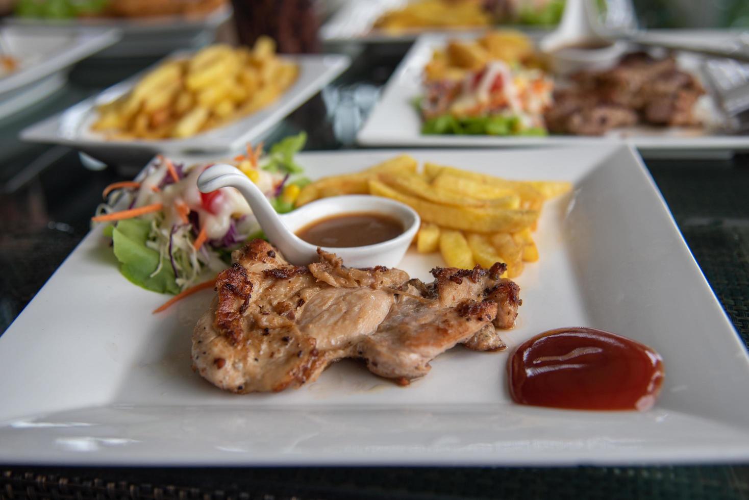 Steak chicken and salad vegetable in dish on table. photo