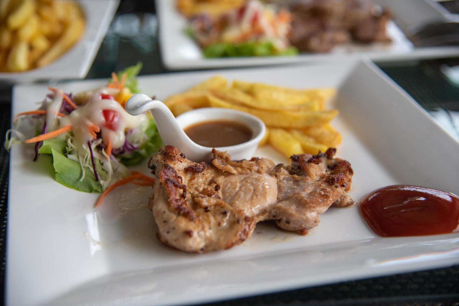 Steak chicken and salad vegetable in dish on table. photo