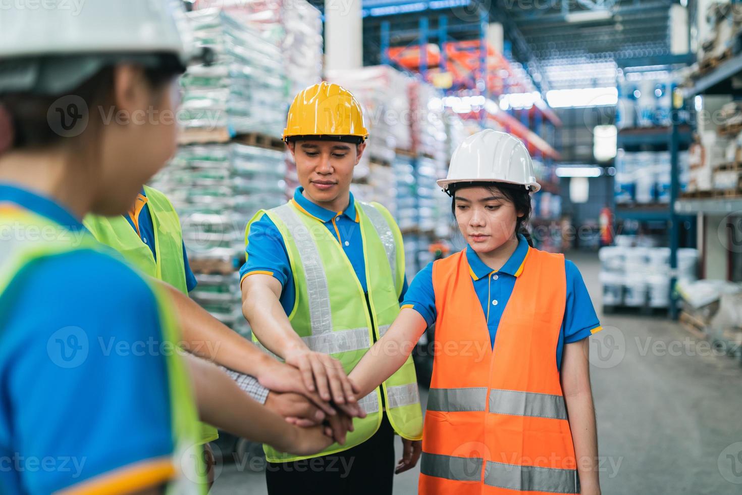Group of industrial warehouse asian worker in safety suite hand stack celebrate successful or deal commitment. Logistics , supply chain and warehouse business.Teamwork unity under view concept. photo