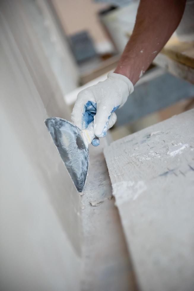 construction worker plastering on gypsum walls photo