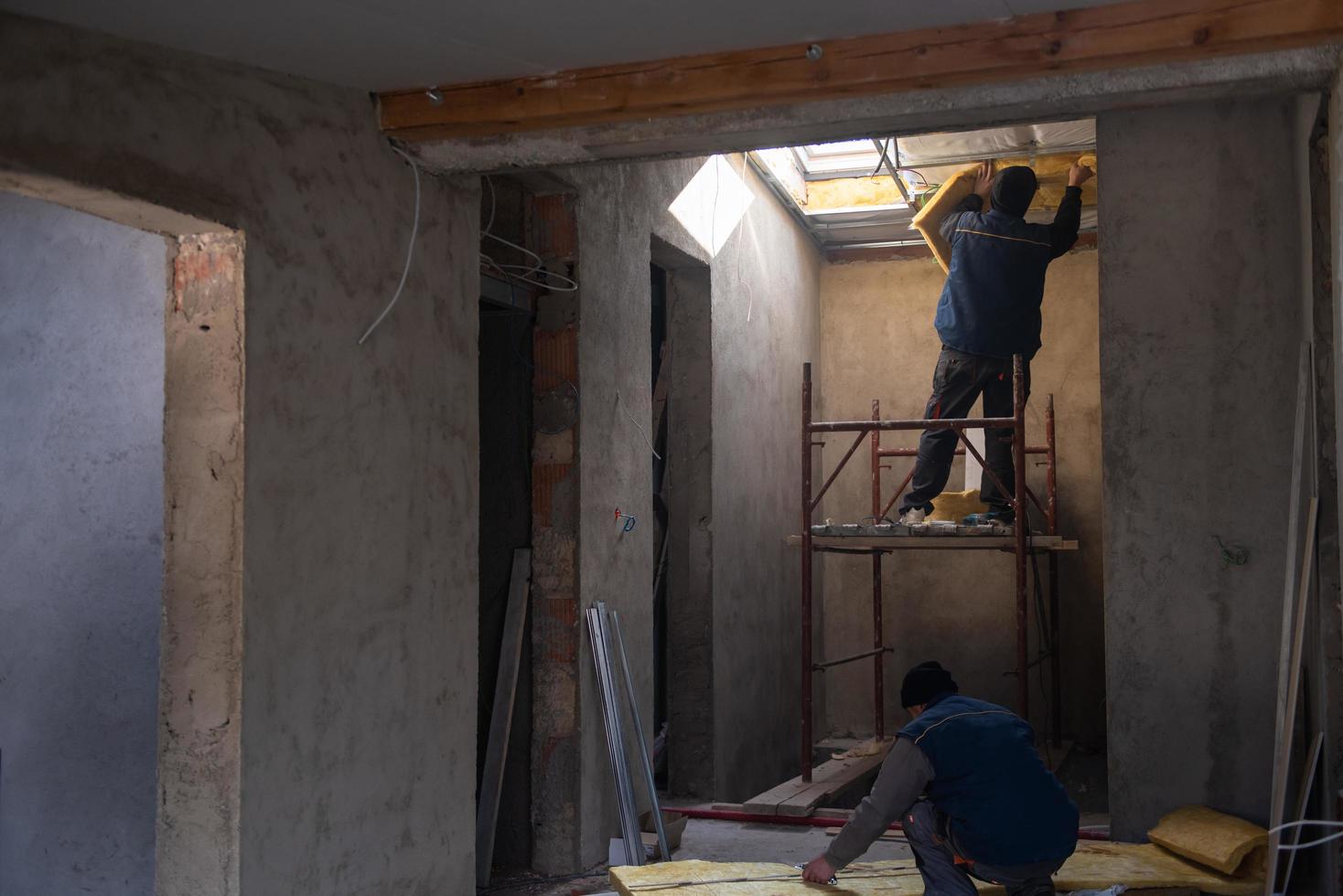 roofer man installing thermal insulation layer photo
