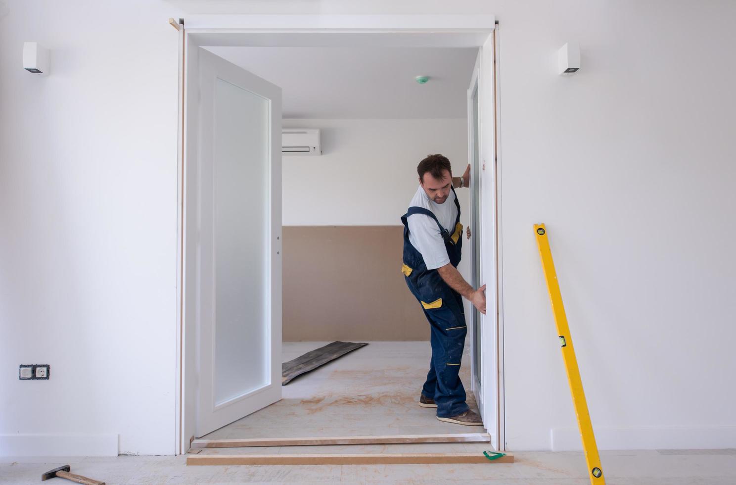 carpenters installing glass door with a wooden frame photo