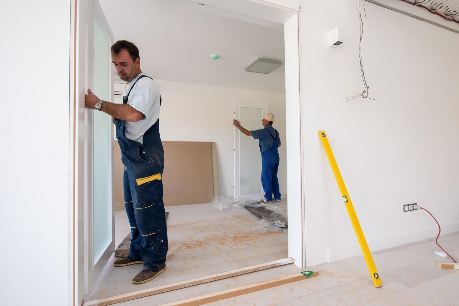 carpenters installing glass door with a wooden frame photo