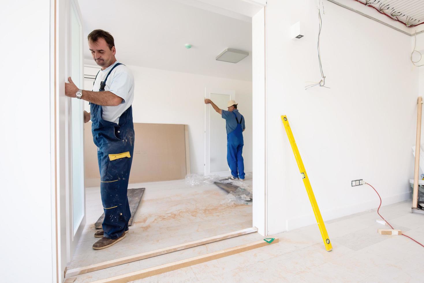 carpenters installing glass door with a wooden frame photo