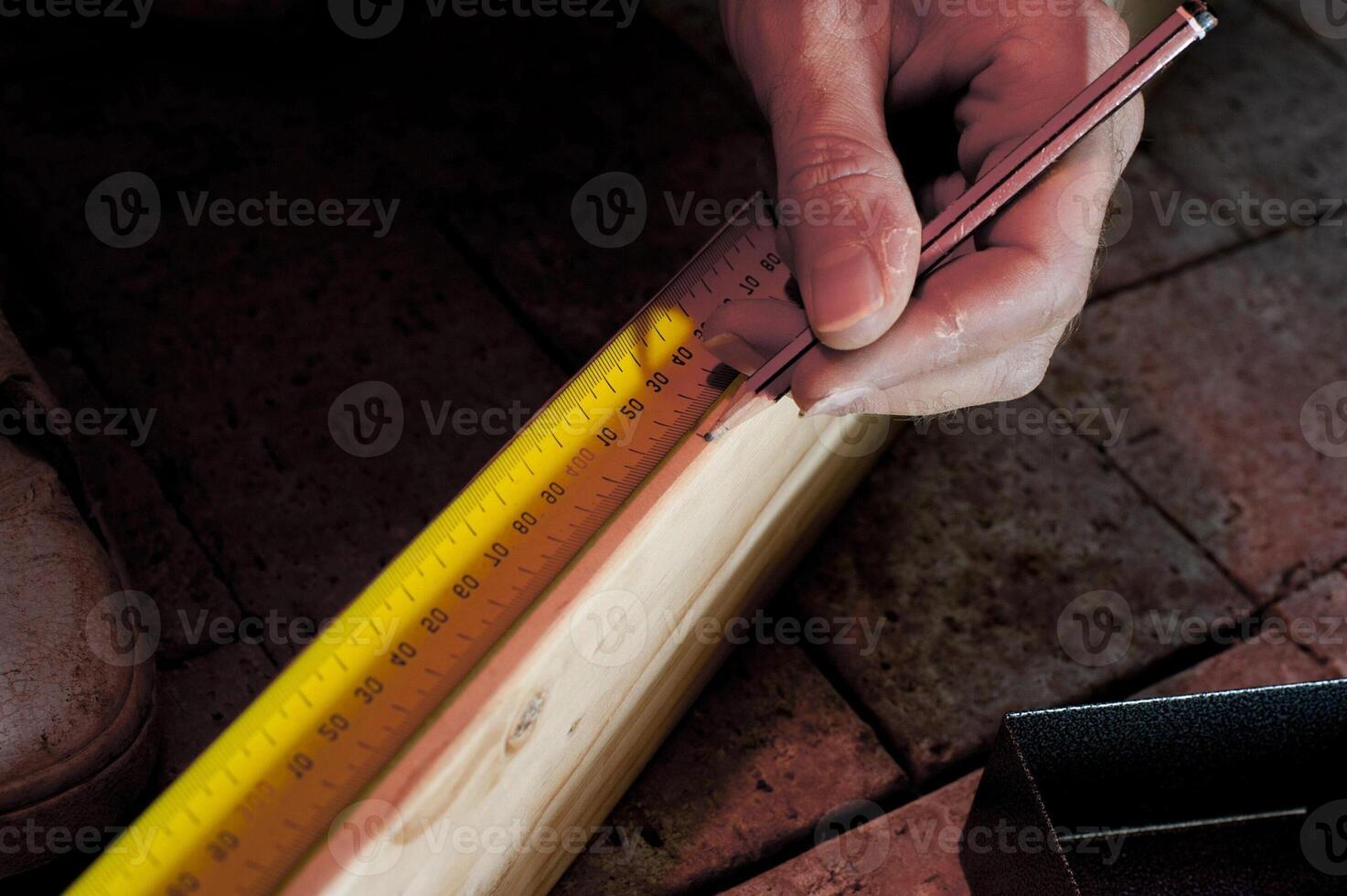 Carpenter measuring a length of wood 11950251 Stock Photo at Vecteezy