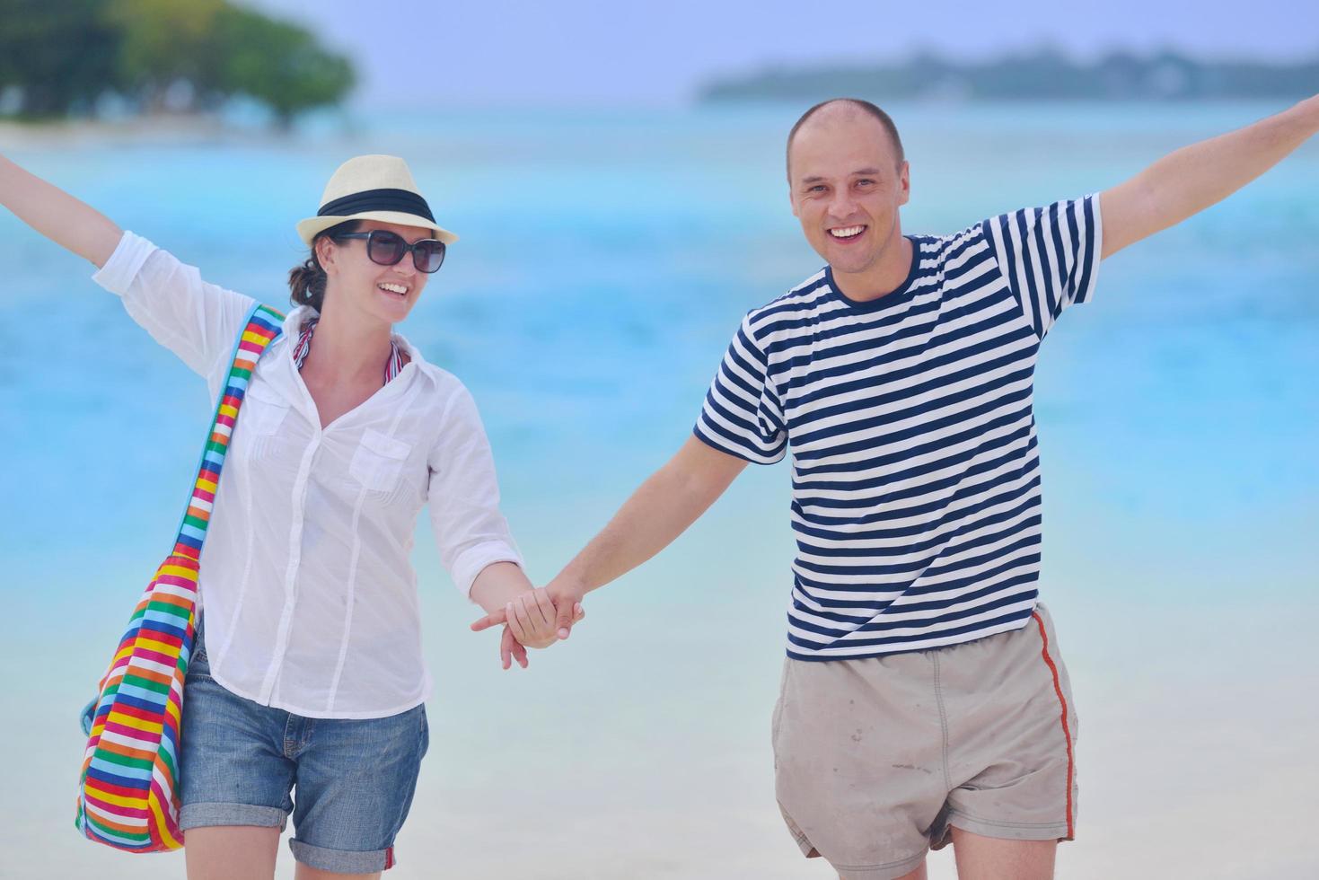 happy young couple have fun on beach photo