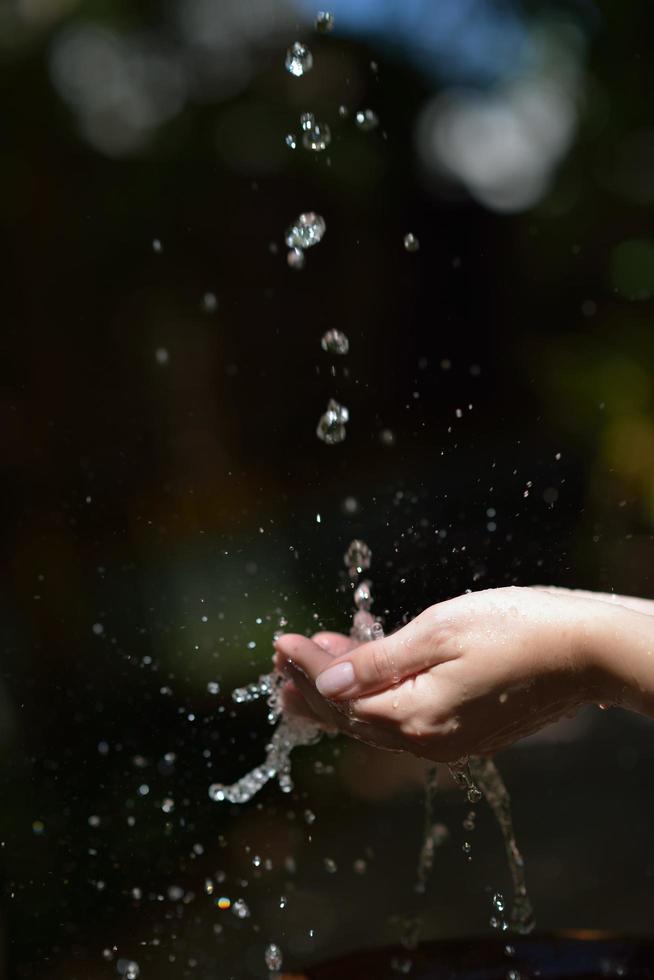 chorro de agua en la mano de la mujer foto