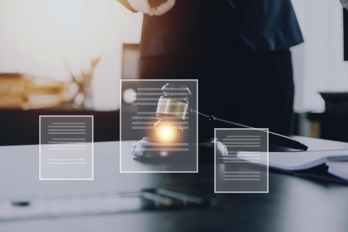 Justice and law concept.Male judge in a courtroom with the gavel, working with, computer and docking keyboard, eyeglasses, on table in morning light photo