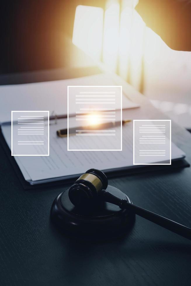 Justice and law concept.Male judge in a courtroom with the gavel, working with, computer and docking keyboard, eyeglasses, on table in morning light photo