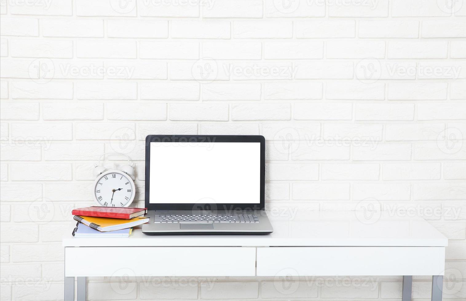 Education accessories on the table near brick wall. Empty computer and mobile screen with place for text. photo