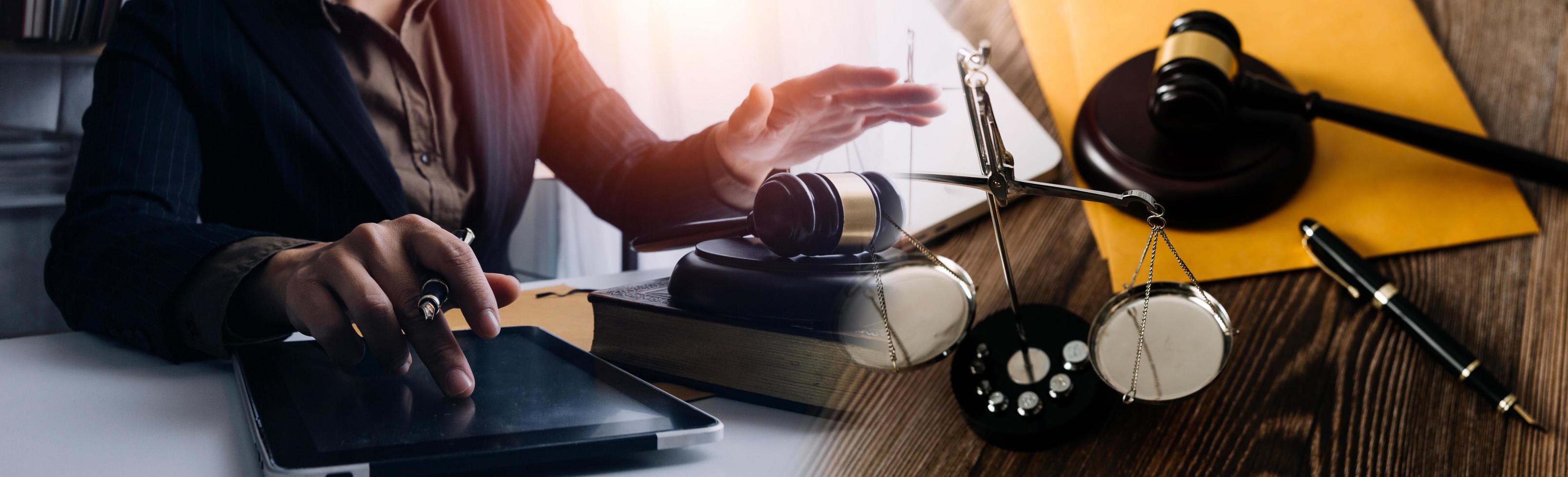 Business and lawyers discussing contract papers with brass scale on desk in office. Law, legal services, advice, justice and law concept picture with film grain effect photo