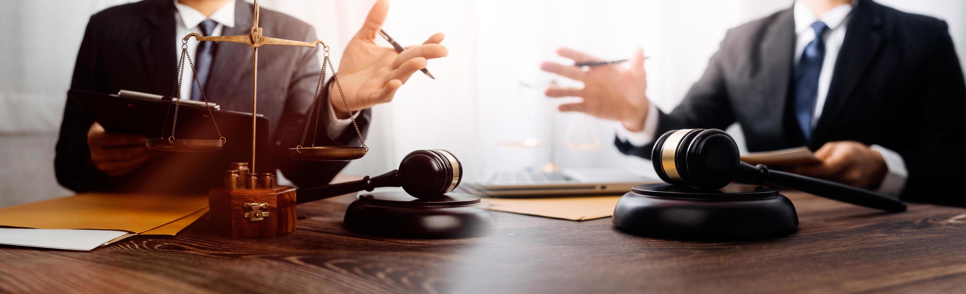 Business and lawyers discussing contract papers with brass scale on desk in office. Law, legal services, advice, justice and law concept picture with film grain effect photo