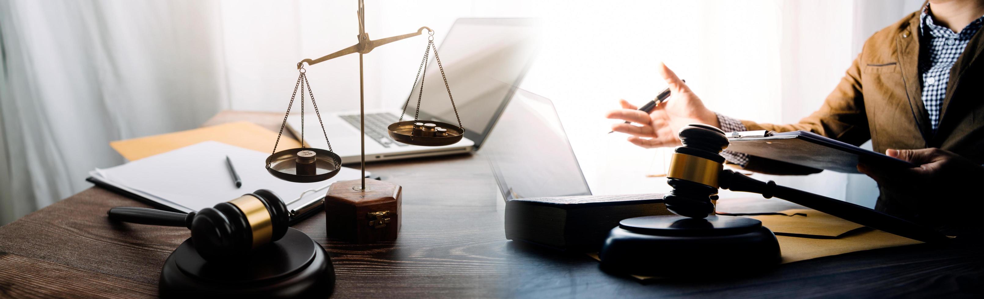 Business and lawyers discussing contract papers with brass scale on desk in office. Law, legal services, advice, justice and law concept picture with film grain effect photo