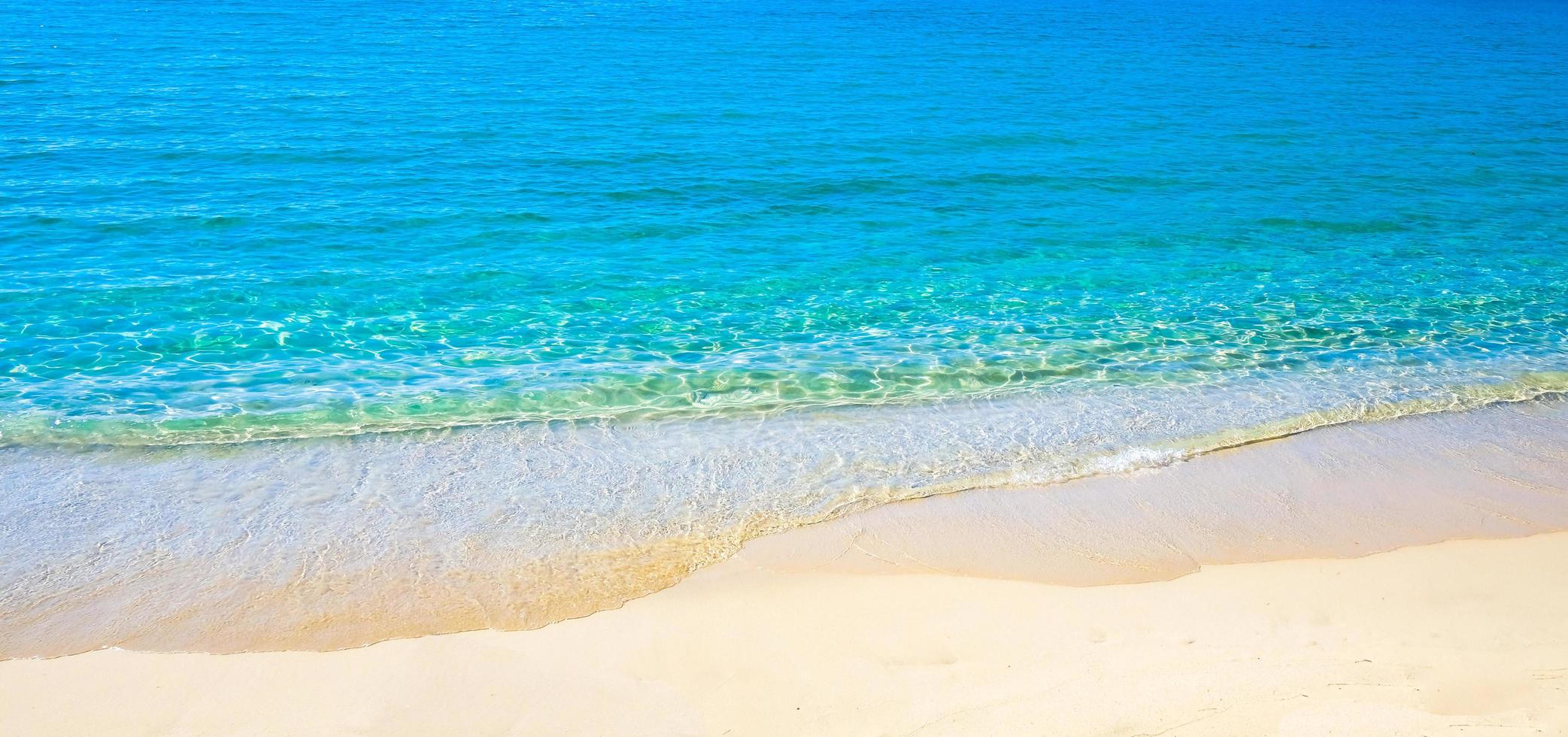 Blue sea surface with waves texture on beach background photo