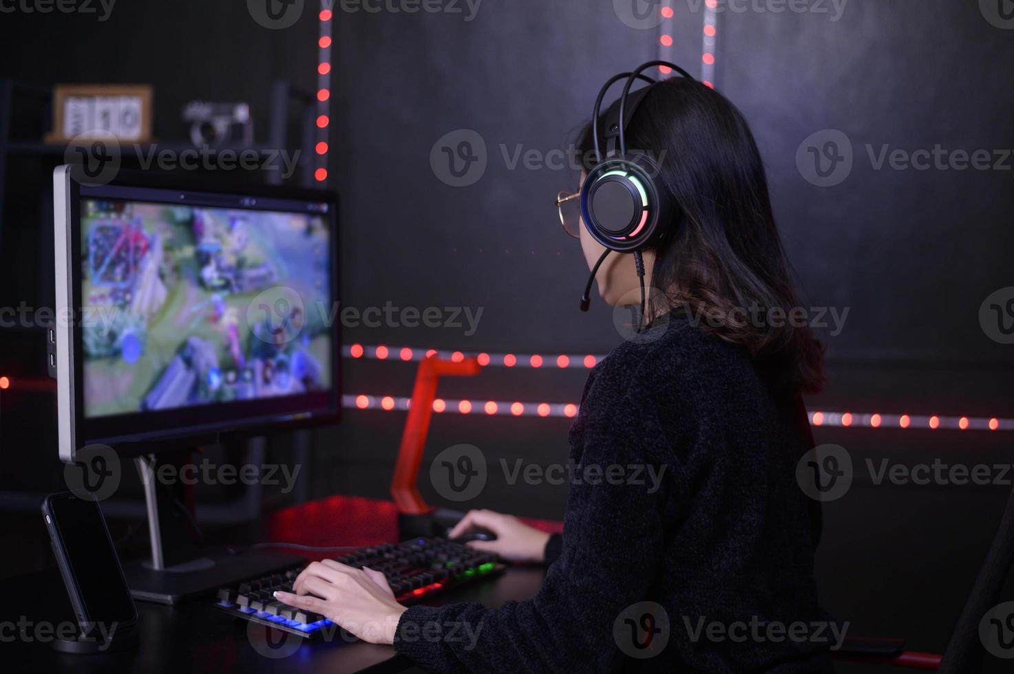 Young female professional Streamer and gamer with headset playing online video games photo