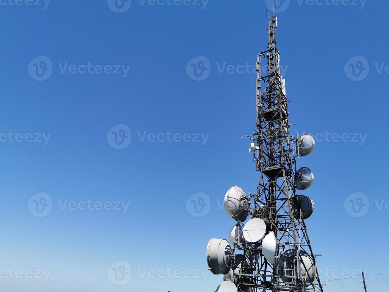 torre de antena de comunicación celular sobre fondo azul foto