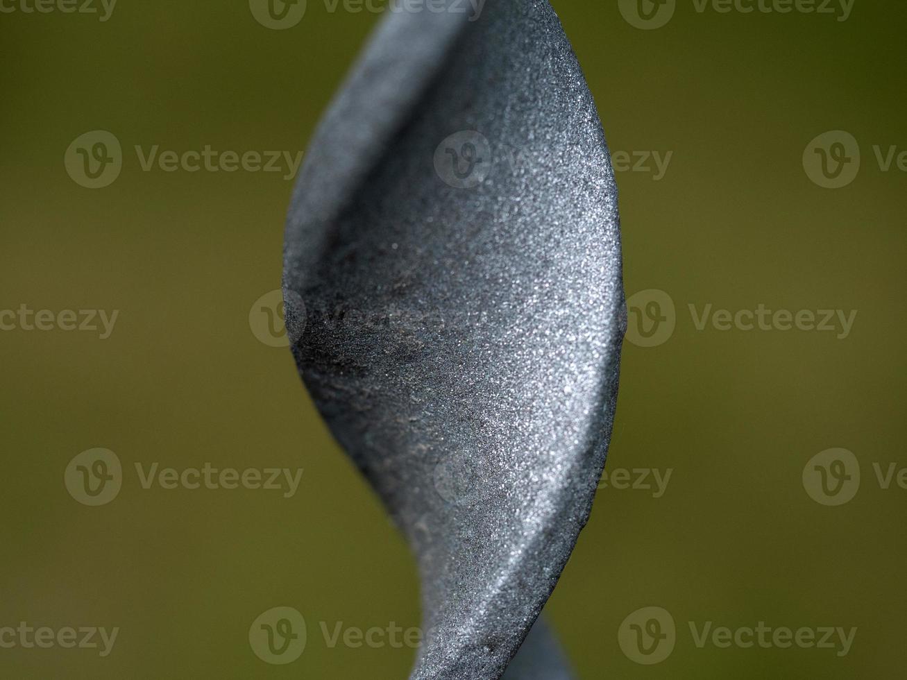 Valla barra de hierro trenzado macro cerrar detalle sobre fondo verde foto