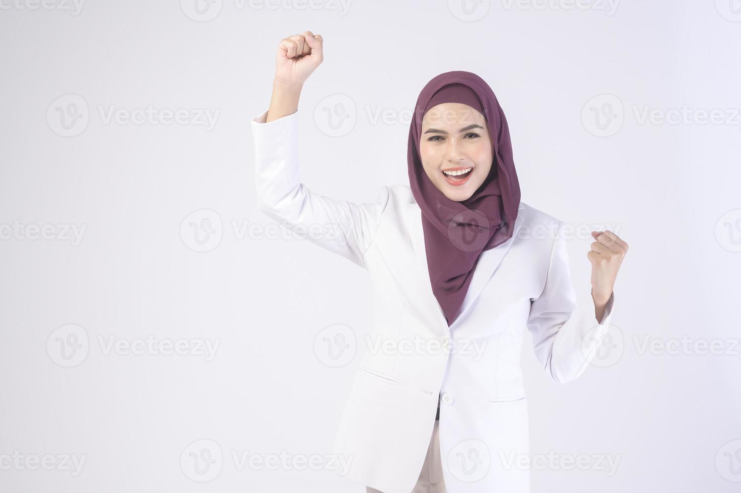 Beautiful muslim business woman wearing white suit with hijab in studio photo