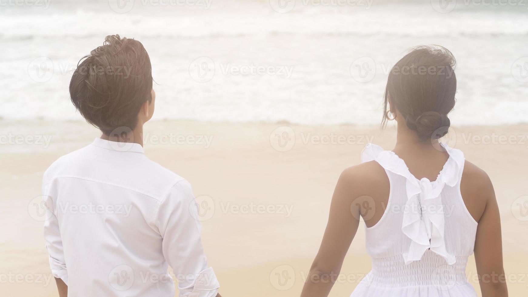 Happy young couple wearing white dress on the beach on holidays, travel, romantic, wedding concept photo