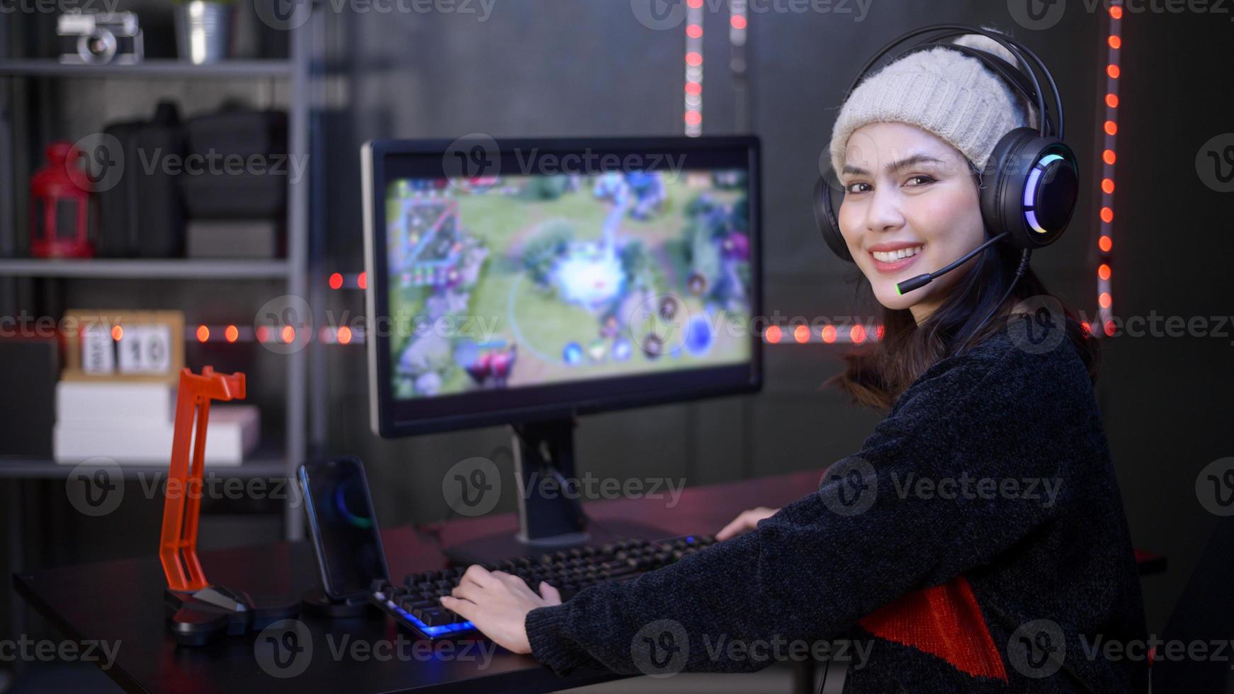 Young female professional Streamer and gamer with headset playing online video games photo