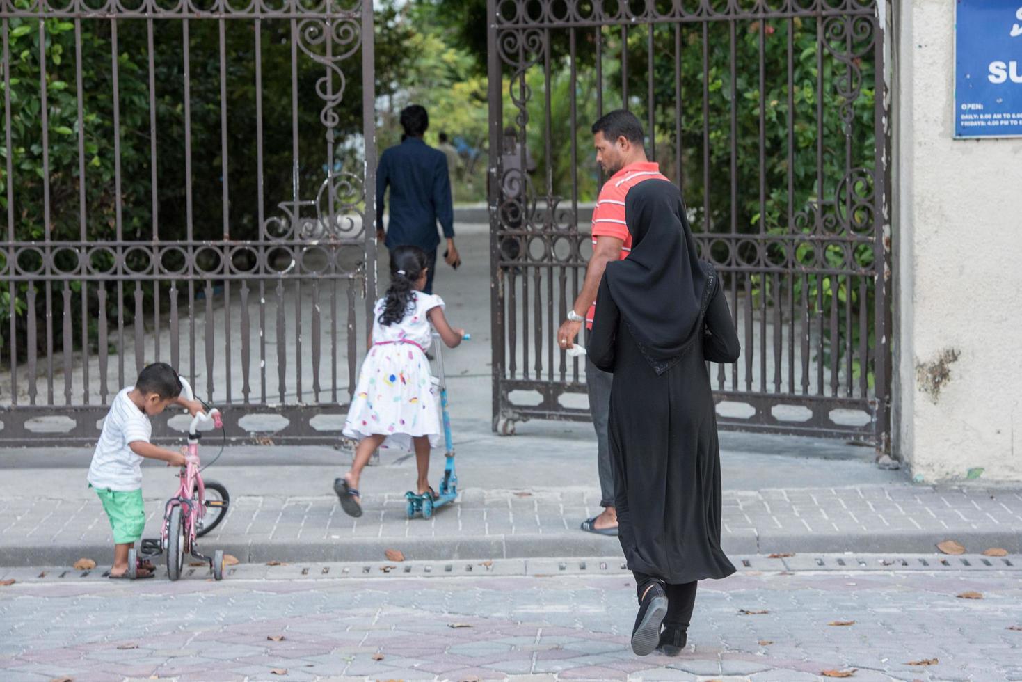 MALE, MALDIVES - FEBRUARY, 13 2016 - People in the street before evening pray time photo