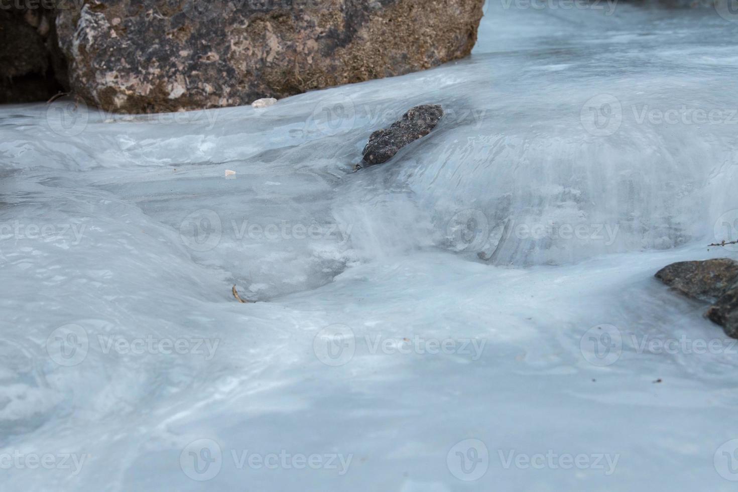 Frozen creek small waterfall in winter time photo