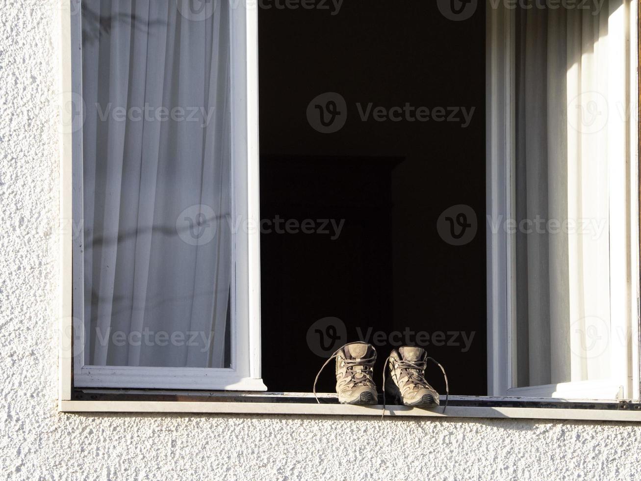 zapatos de trekking secándose fuera de la ventana foto